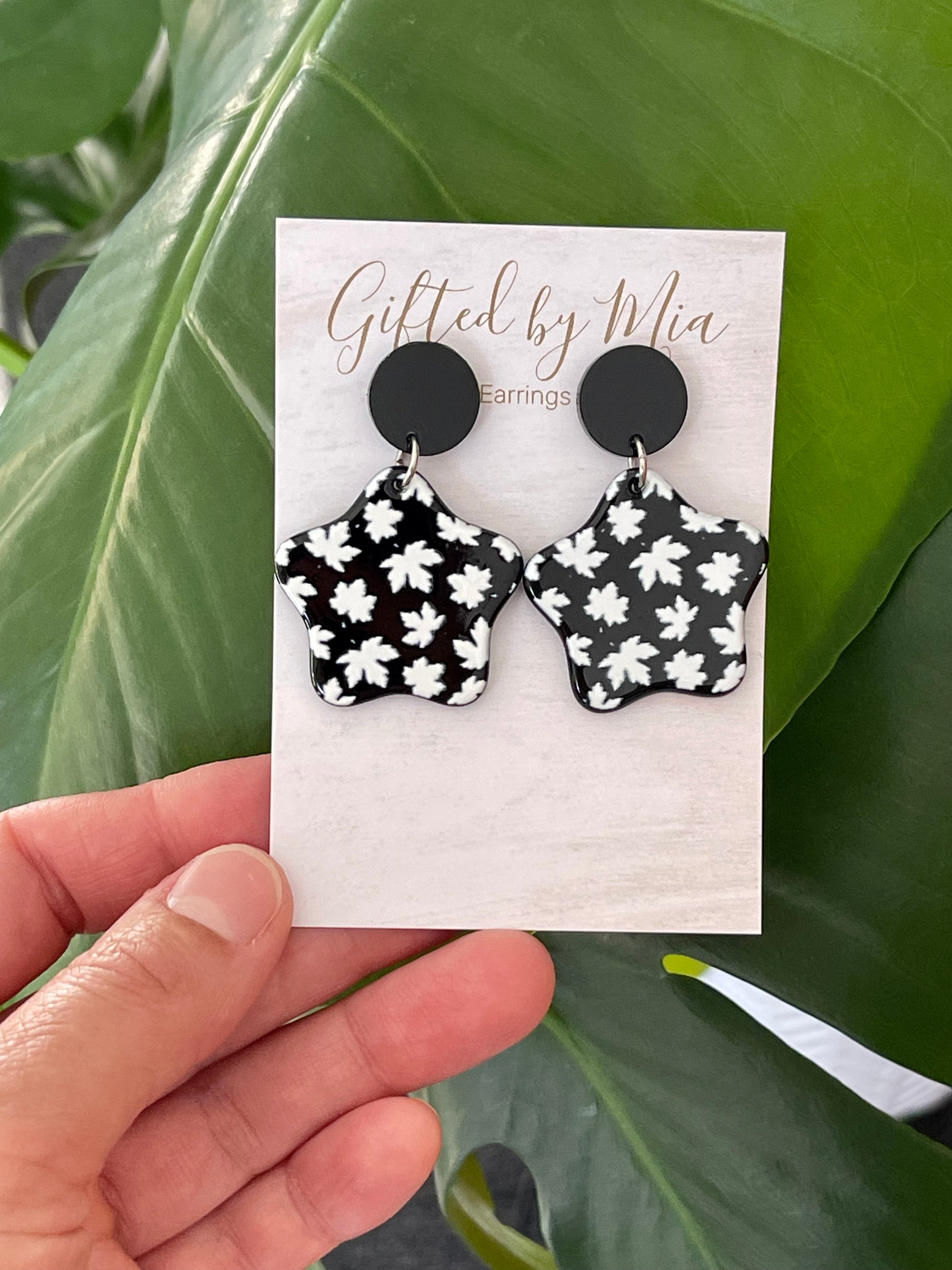 Black star earrings with maple leaf print